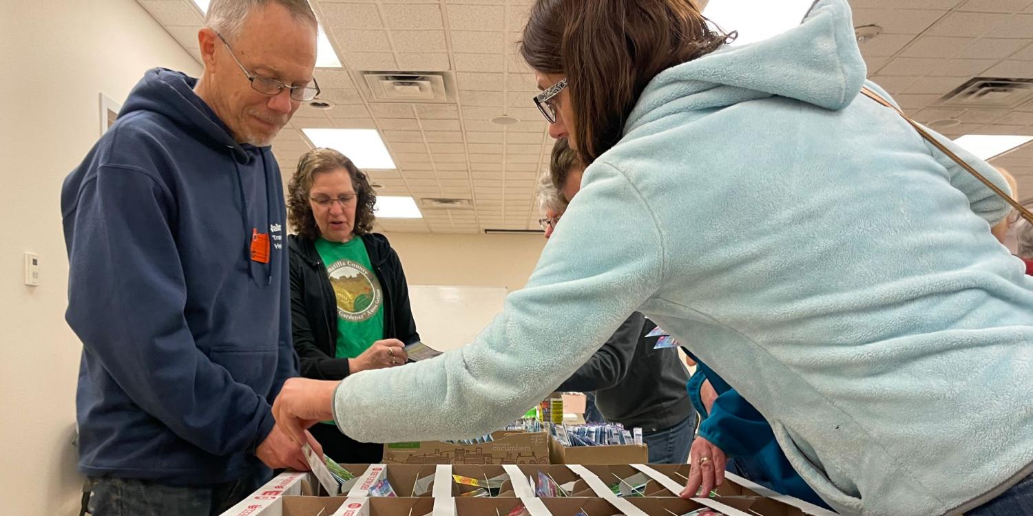 OSU Extension Matser Gardeners Joe Hodge (left) and Lisa Dahlin help Seed to Supper participants in Hermiston select free seeds to start their gardens.
