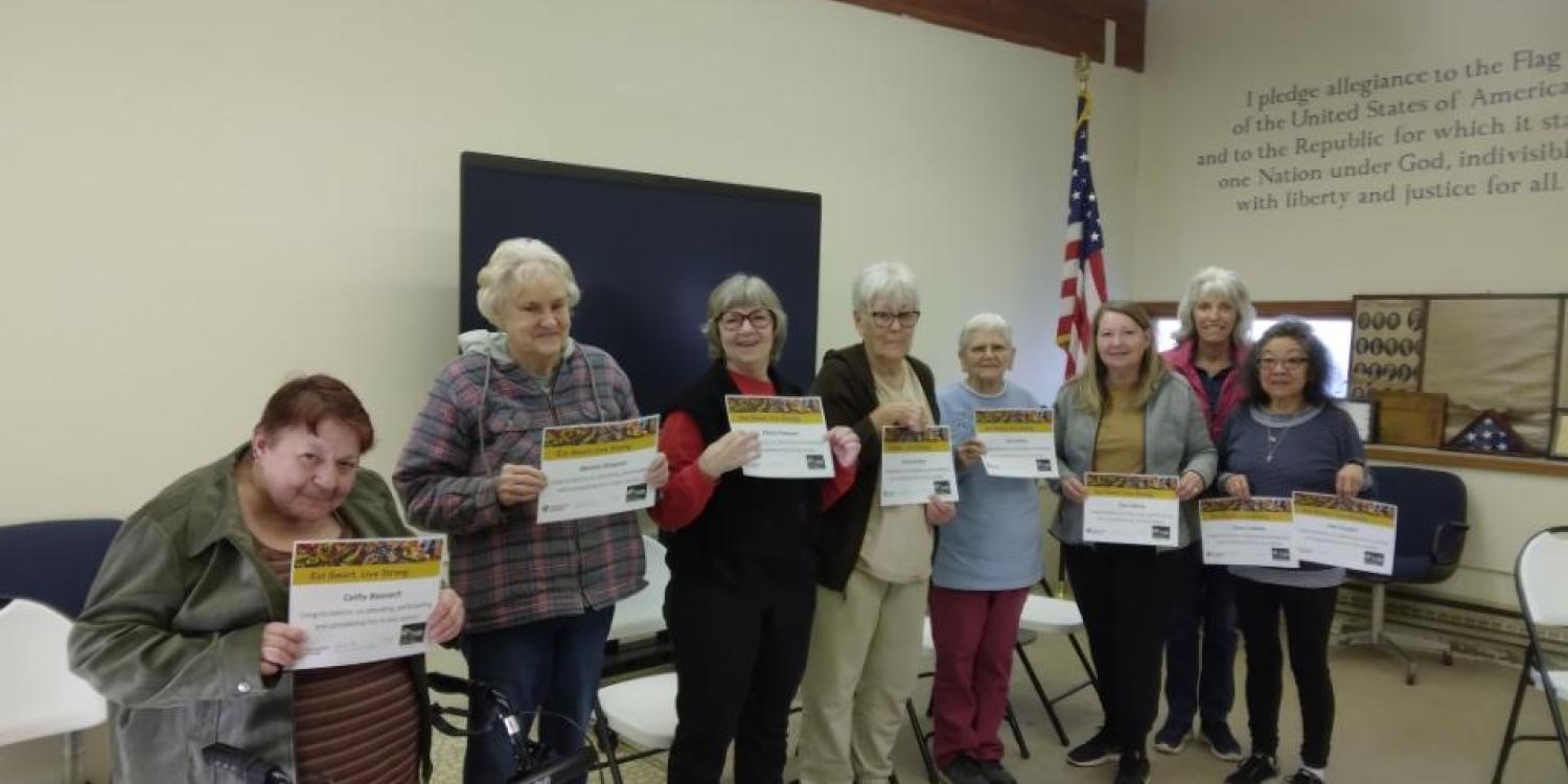 Graduates of the “Eat Smart Live Strong” series held in Rufus hold up their certificates for a photo.