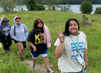 Teenagers are on a hike on a forest meadow.