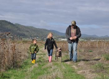 Land Steward Russell Kockx (far right) and his children walk along their property in Central Point, Ore.