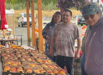 Members ofthe Confederate Tries of Warm Springs shop for peaches at a fruit stand in Hood River County.