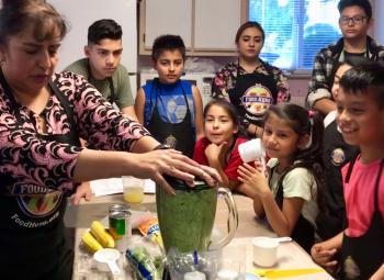 In 2018, Maria Falcon teaches the Healthy Kids Club how to make a delicious and nutritious smoothie.